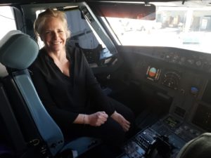 Client posing in the cockpit on a flight to Las Vegas after 3 sessions of hypnosis to overcome fear of flying
